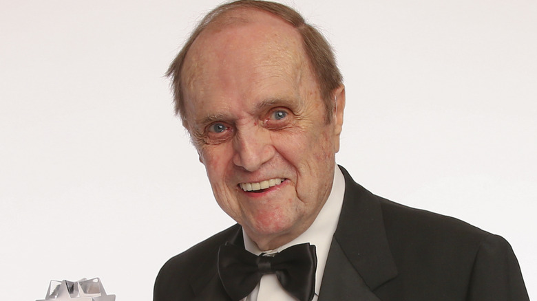 Bob Newhart smiles holding a trophy