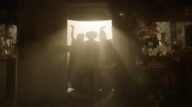 Sanderson sisters standing in silhouette in a doorway