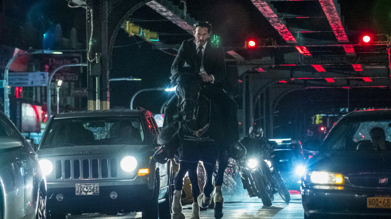 John Wick riding a horse in city