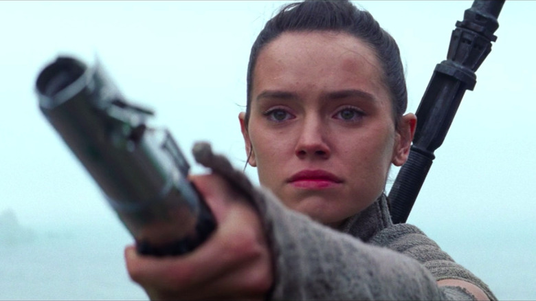 Rey offering Luke Skywalker's lightsaber