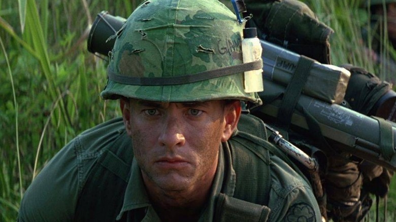Tom Hanks crawls in army helmet and fatigues