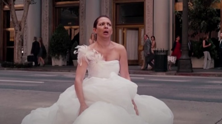 Bridesmaids Lillian in a wedding dress collapses in the street