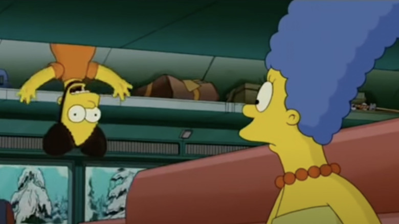 Bart pranking Marge while wearing Mickey ears