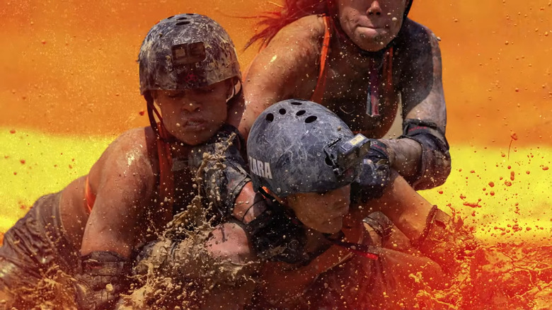 Contestants wrestling in mud