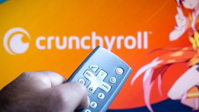 man points remote at Crunchyroll app
