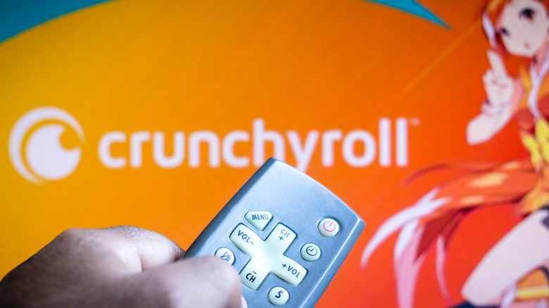 man points remote at Crunchyroll app