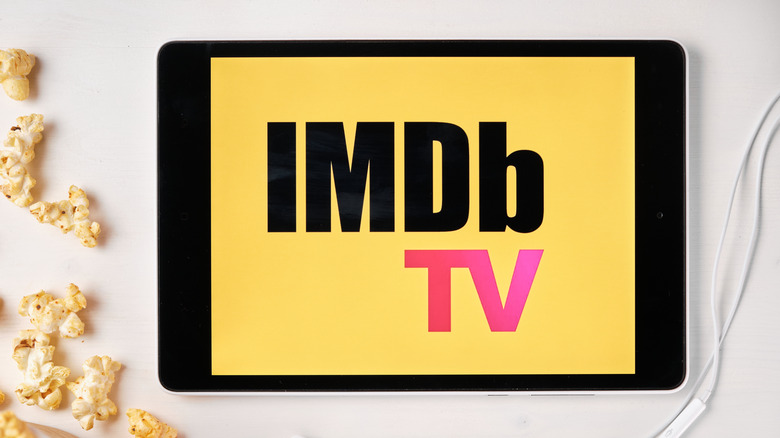 IMDb TV logo on tablet surrounded by popcorn