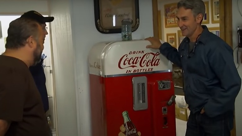 Mike Wolfe leaning on a Coca Cola machine