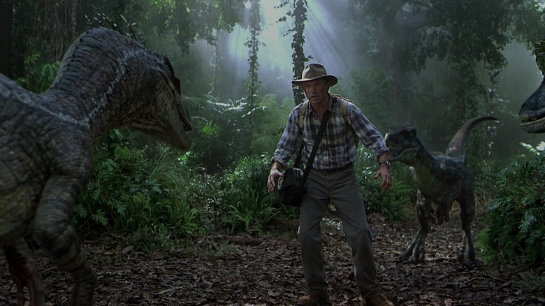 Alan Grant surrounded by velociraptors