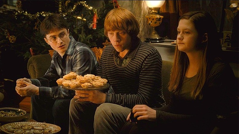 Harry, Ron, and Ginny sitting on a couch