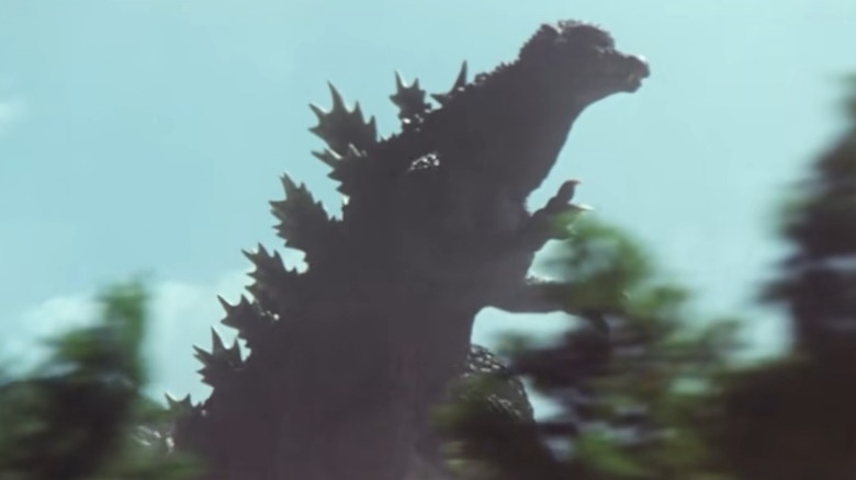 Godzilla running through a forest