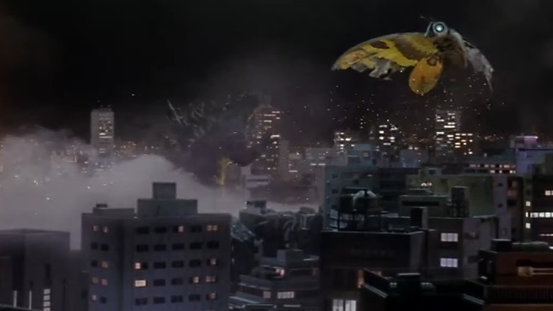 Godzilla and Mothra fight amidst buildings