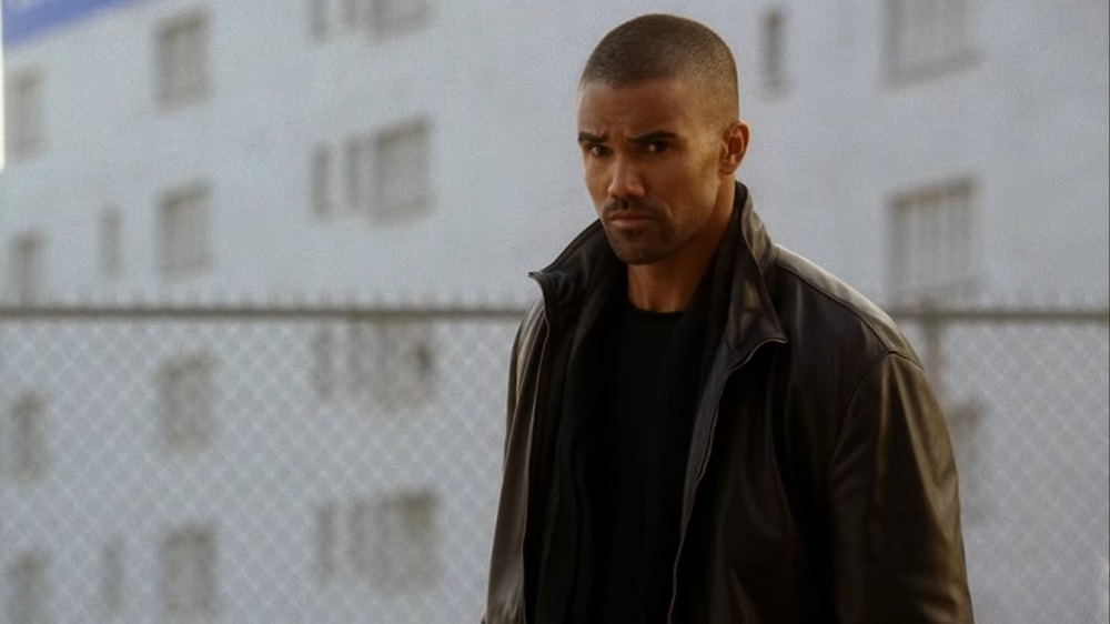 Derek Morgan in front of fence