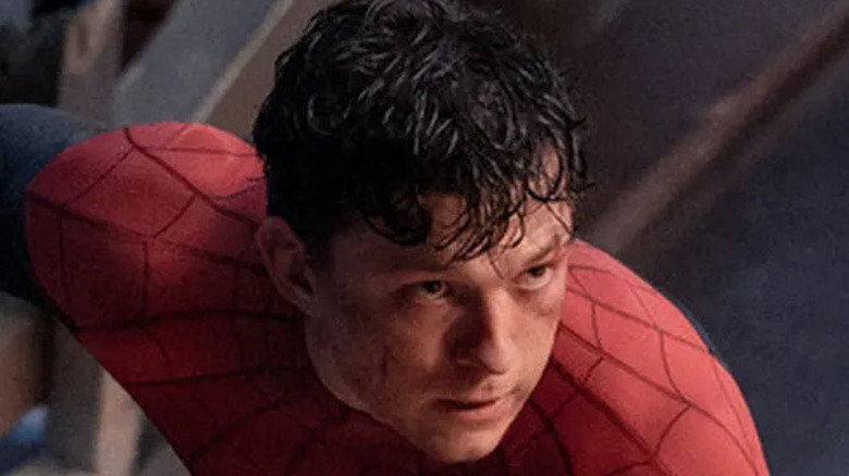 An unmasked Peter Parker crouches down