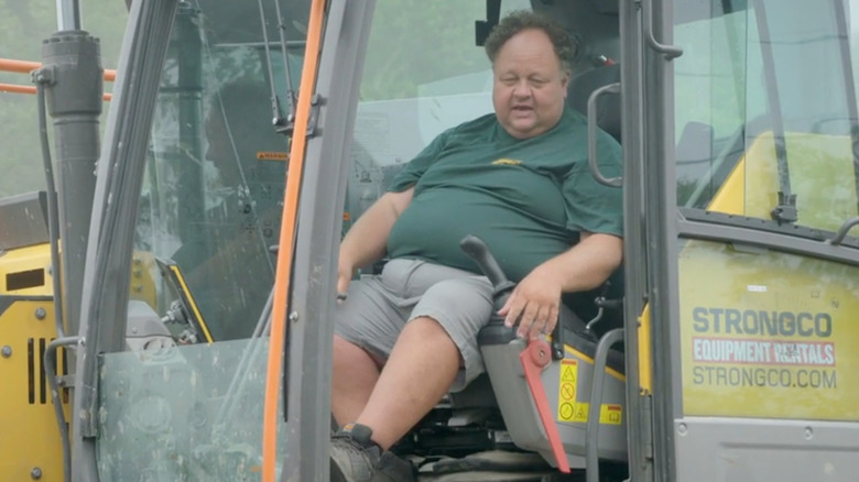 Billy Gerhardt sits in an excavator on The Curse of Oak Island (2014-present)