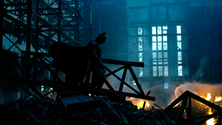 Batman standing over building rubble