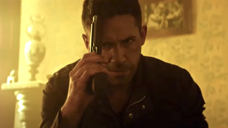 Scott Adkins holding gun