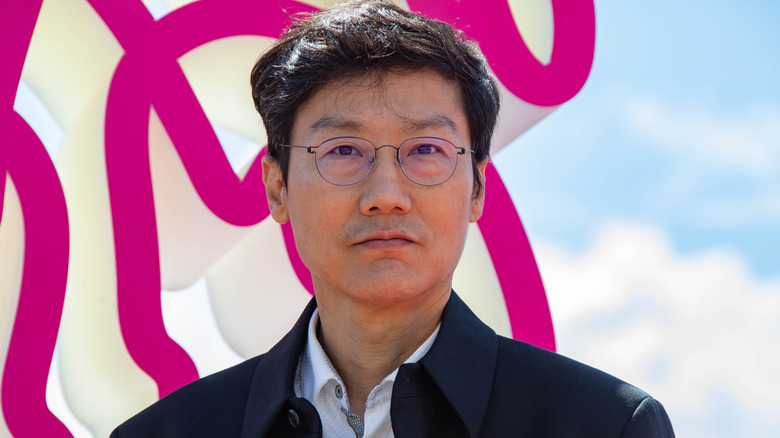 Hwang Dong-hyuk at Cannes 2022 in front of pink and white structure