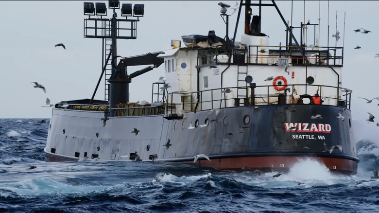 The F/V Wizard sailing at sea with birds flying around the hull