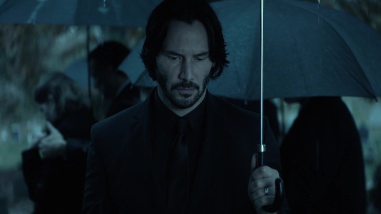 John Wick holding umbrella at funeral