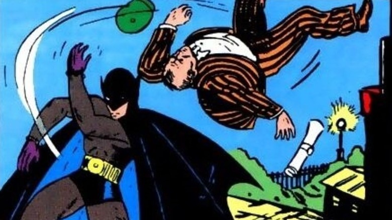 Batman throwing a criminal through the air