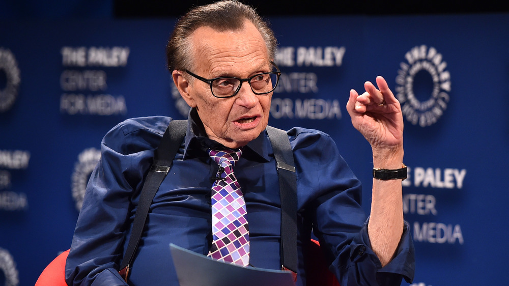 Larry King holding papers