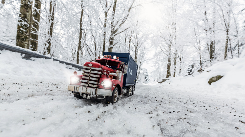 Truck driving in snow-covered forest