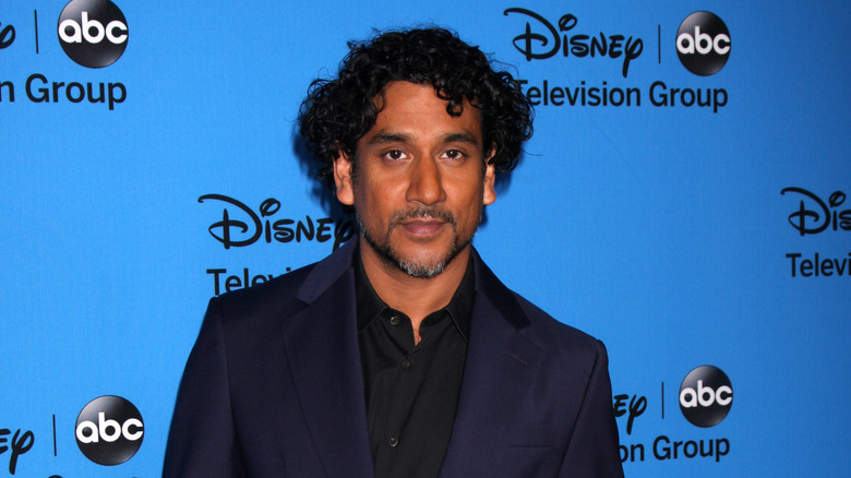 Naveen Andrews in front of blue background