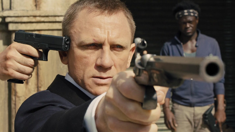 James Bond (Daniel Craig) aims a pistol with a gun to his own head in "Skyfall"