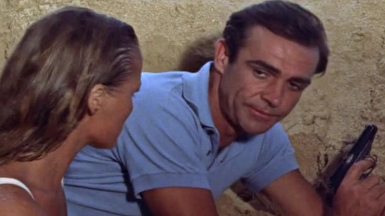 Honey Ryder (Ursula Andress), James Bond (Sean Connery), and Quarrel (John Kitzmiller) behind a sandbar in "Dr. No"