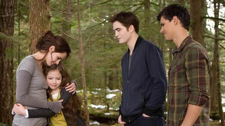 Bella hugs Renesmee with Jacob and Edward watching