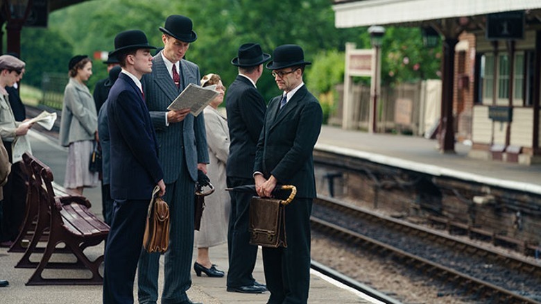 Men stand quietly on train platform