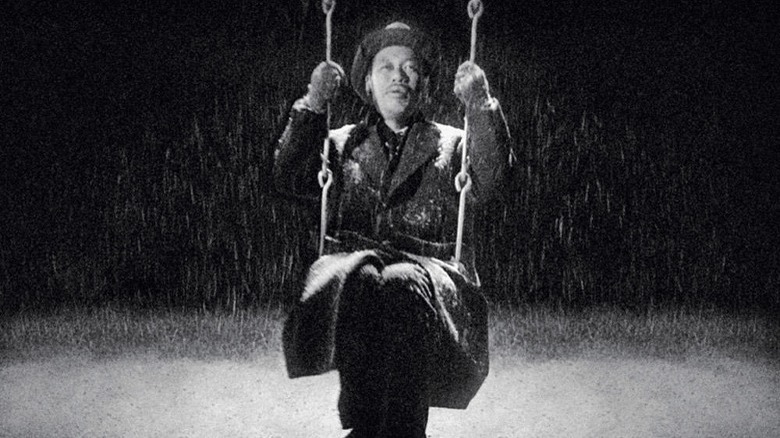 Kanji Watanabe sits on swing in snow