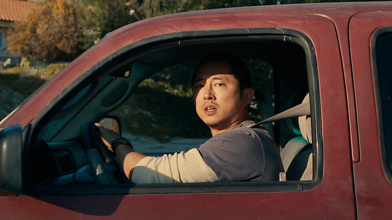 Steven Yeun driving a truck