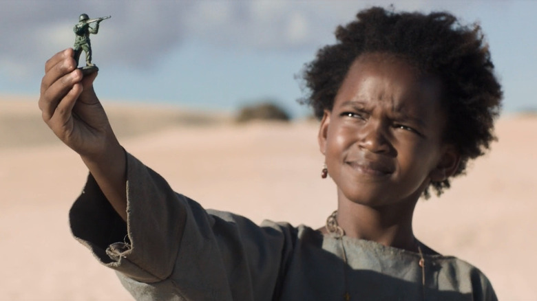 Berber's daughter holds toy soldier