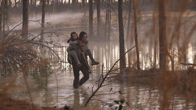 Mills carrying Koa through a swamp