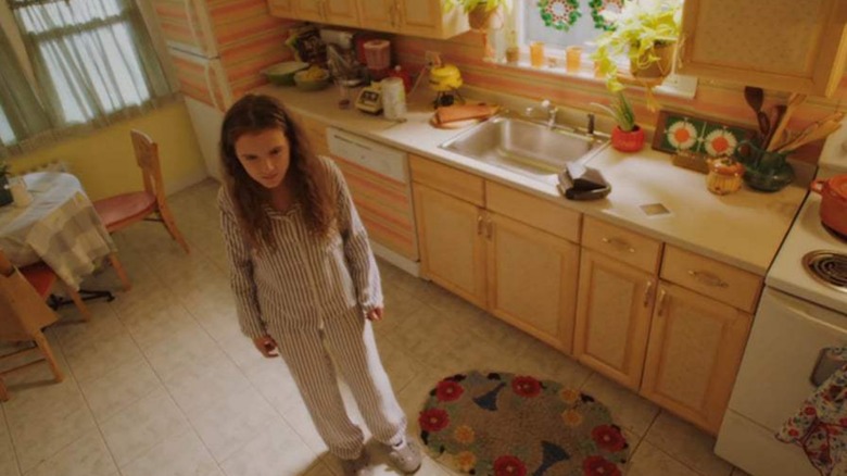 Young Holly standing in empty kitchen