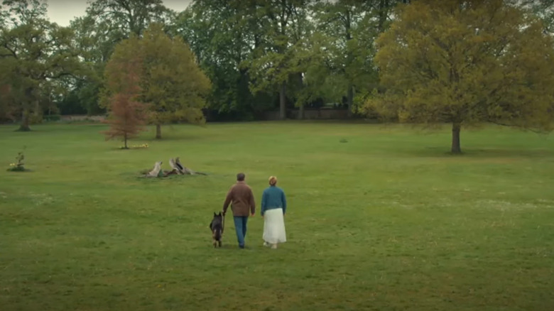 A man a woman and a dog in a field After Life