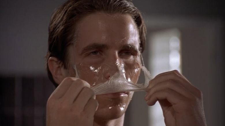 Patrick Bateman peels off face mask