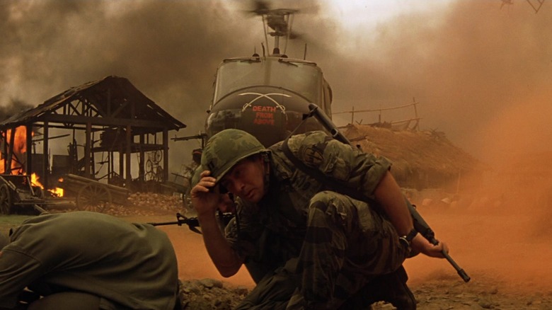 Martin Sheen crouching outside a helicopter