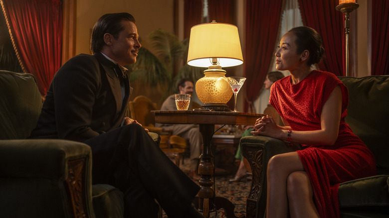 Jack Conrad and Lady Faye Zhu sit at a small table, smiling with drinks