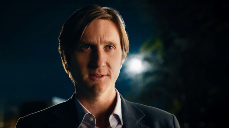 Simon standing in suit at night