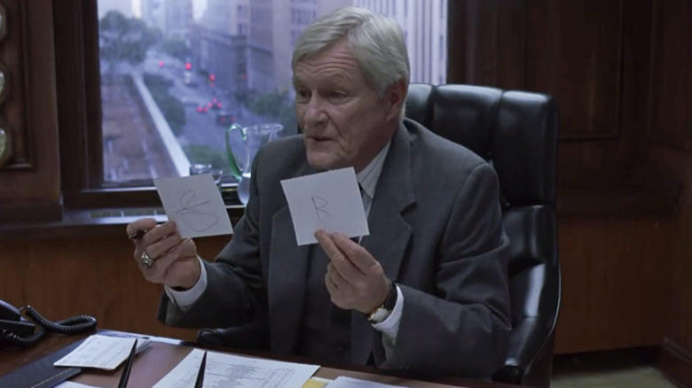 Orson Bean holding two cards