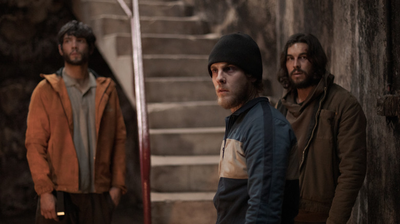 Three men standing by staircase