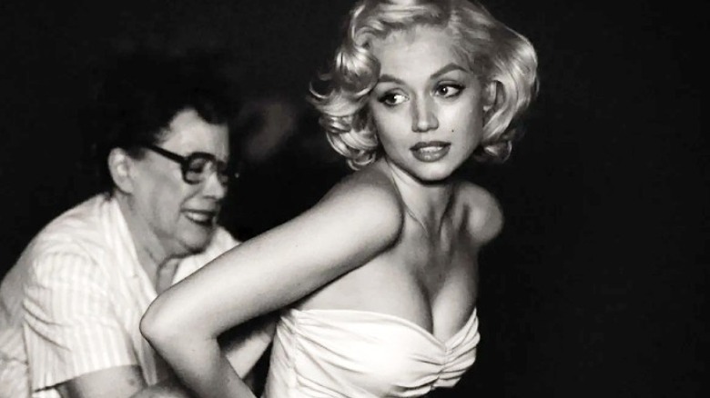 A woman helps Norma Jeane fit into dress