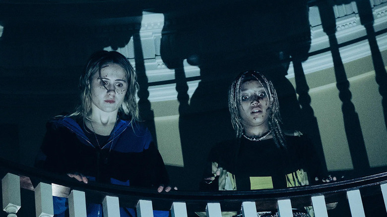 Amandla Stenberg and Maria Bakalova looking over a bannister 