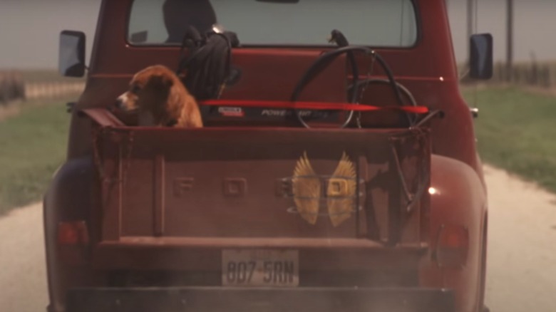 A red Ford pickup driving away