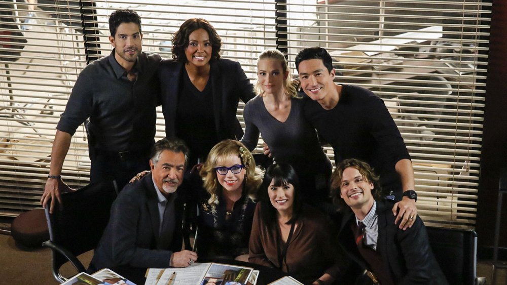 the season 15 cast of Criminal Minds on-set in their briefing room