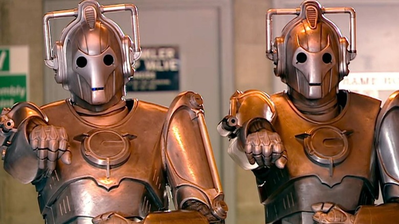 Two Cybermen aiming their weapons