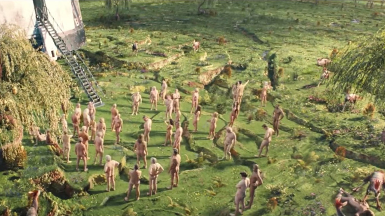 a group of naked humans explore a new planet